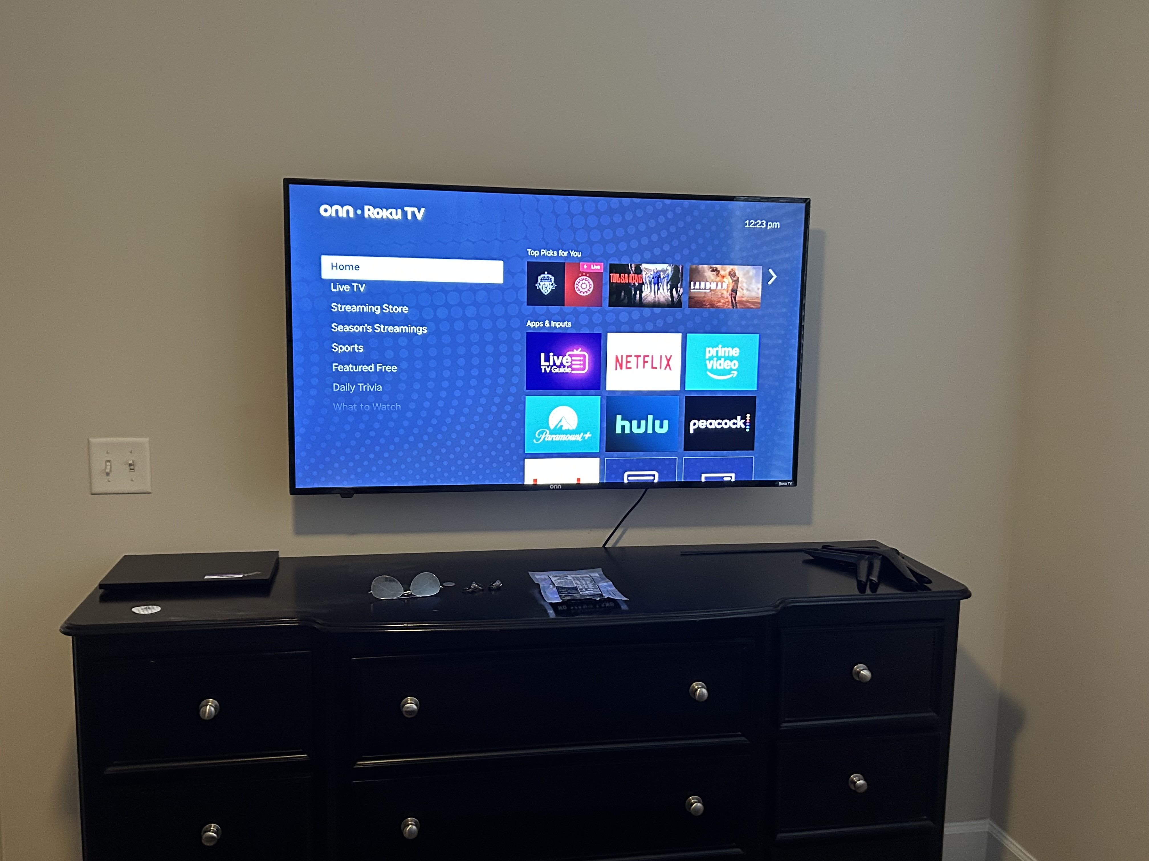 Bedroom TV mounted on wall; turned on